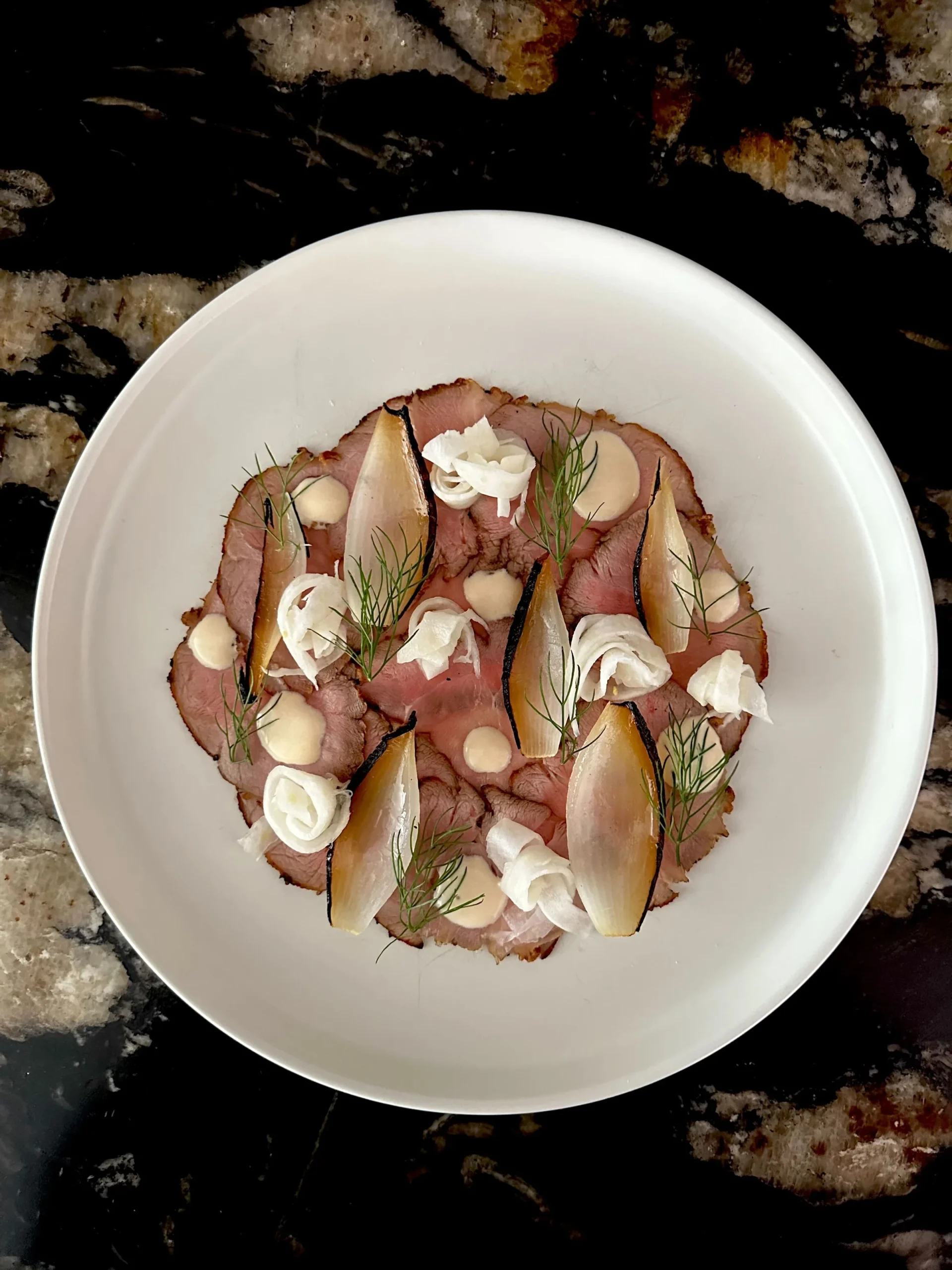 Vitello tonnato with herbs and pickled garnish