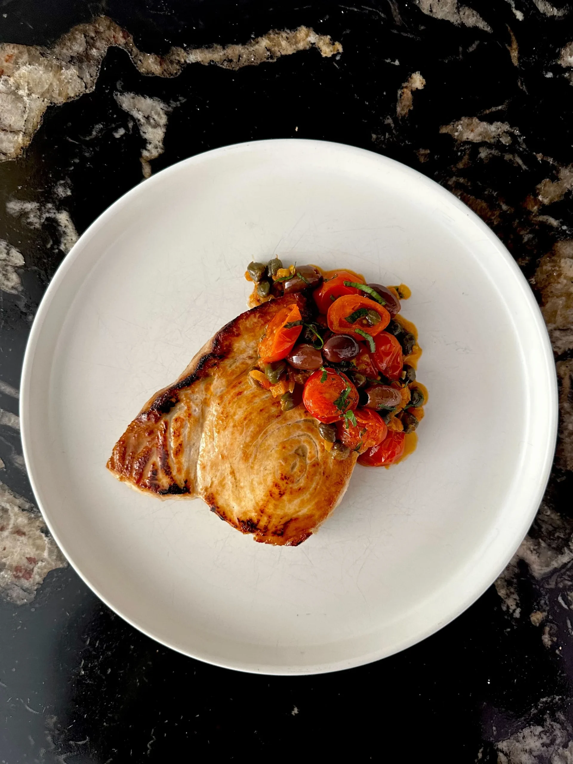Grilled fish with tomatoes, olives, and capers