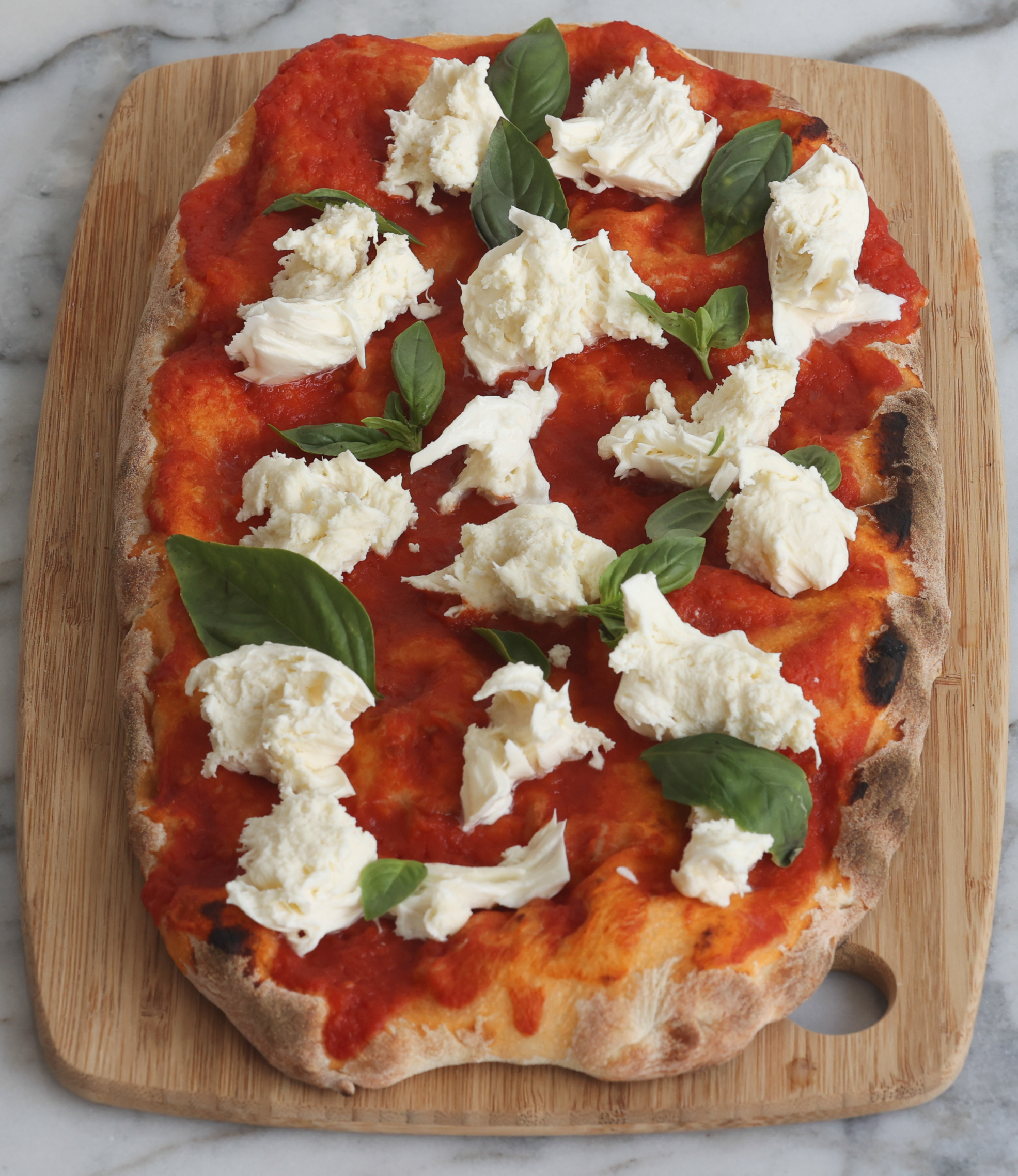 Margherita pinsa with tomato, mozzarella, and basil
